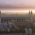 Vista panorámica de la Capilla de King's College en Cambridge, Reino Unido, con el cielo teñido de tonos dorados al atardecer.