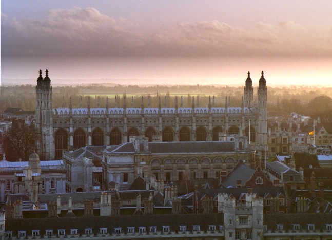 Vista panorámica de la Capilla de King's College en Cambridge, Reino Unido, con el cielo teñido de tonos dorados al atardecer.